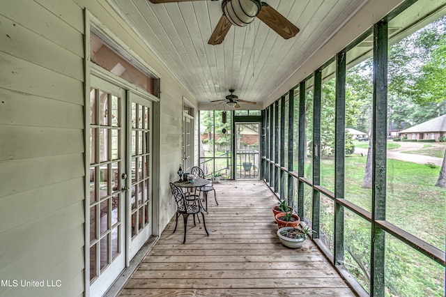 unfurnished sunroom featuring wood ceiling and ceiling fan