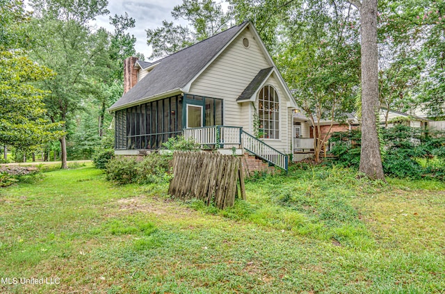 back of house featuring a yard and a sunroom