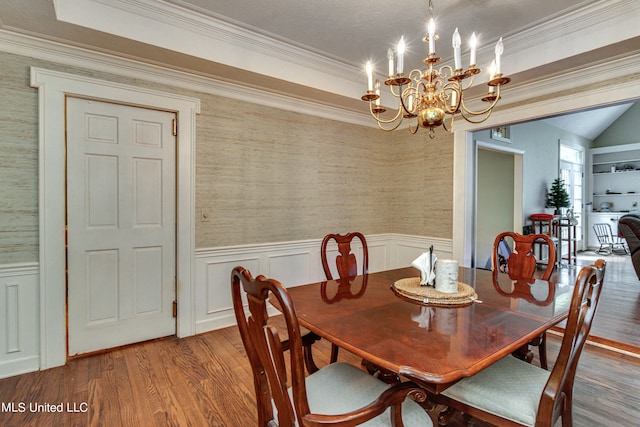 dining room featuring crown molding, a notable chandelier, and hardwood / wood-style flooring