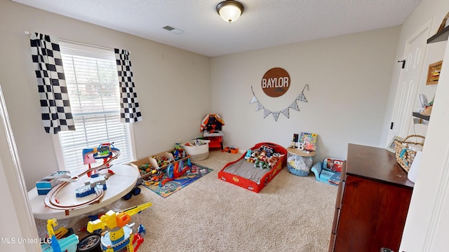 game room featuring visible vents, a textured ceiling, and carpet floors