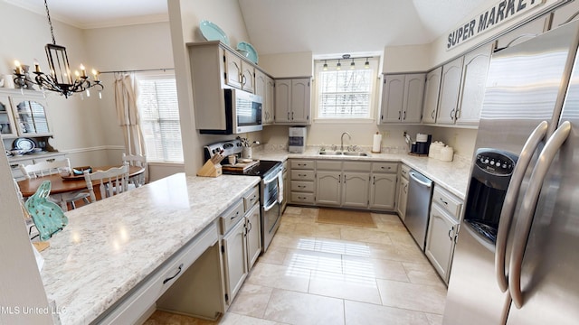 kitchen with a chandelier, lofted ceiling, hanging light fixtures, stainless steel appliances, and a sink