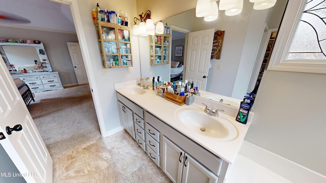 bathroom with double vanity, ornamental molding, baseboards, and a sink