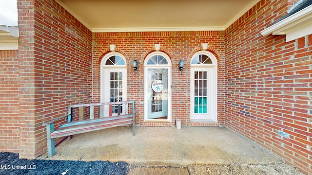 doorway to property featuring brick siding