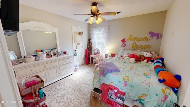 carpeted bedroom with visible vents, a textured ceiling, and a ceiling fan