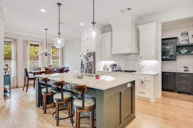 101 Coventry Ln, Canton, MS 39046 - kitchen with light countertops, light wood-style flooring, stainless steel fridge, tasteful backsplash, and custom range hood