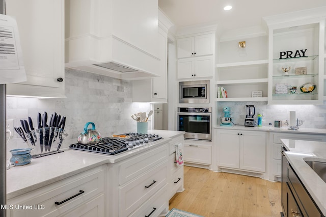 101 Coventry Ln, Canton, MS 39046 - kitchen featuring custom exhaust hood, open shelves, tasteful backsplash, light wood-type flooring, and appliances with stainless steel finishes