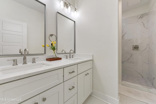 bathroom with tile patterned flooring, a tile shower, and vanity