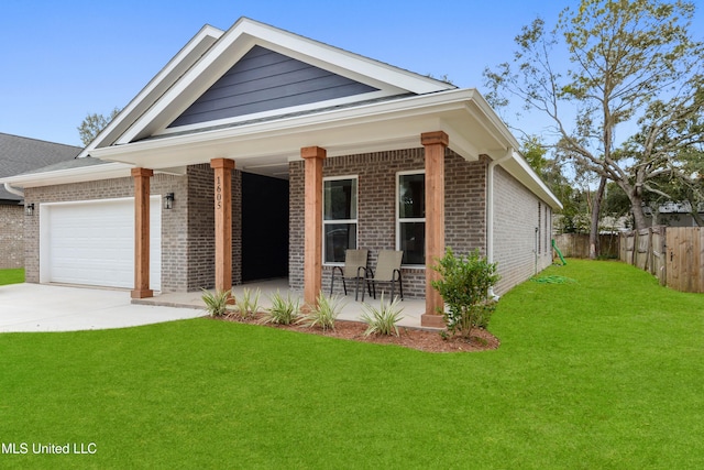 view of front of property featuring a front yard, a garage, and a porch