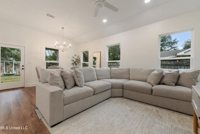 living room featuring ceiling fan with notable chandelier, vaulted ceiling, and light hardwood / wood-style flooring