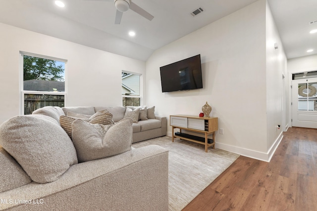 living room featuring ceiling fan, lofted ceiling, plenty of natural light, and wood-type flooring