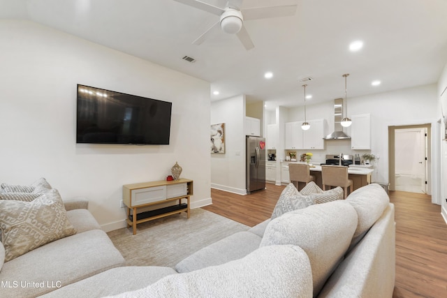 living room with ceiling fan and light hardwood / wood-style floors