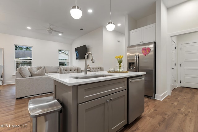 kitchen with an island with sink, gray cabinetry, appliances with stainless steel finishes, ceiling fan, and sink