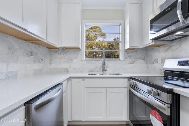 kitchen featuring sink, white cabinetry, stainless steel appliances, and tasteful backsplash