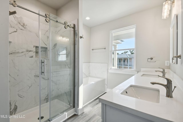 bathroom with hardwood / wood-style flooring, vanity, and an enclosed shower