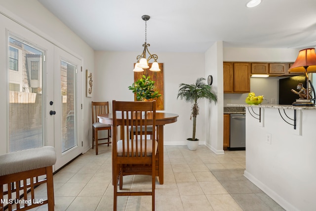 tiled dining space featuring french doors and a notable chandelier