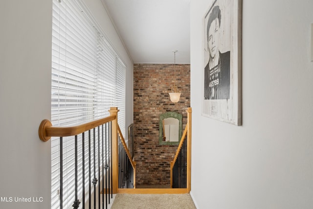 staircase featuring brick wall