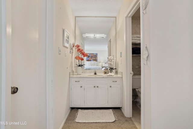 bathroom featuring vanity, a textured ceiling, and toilet