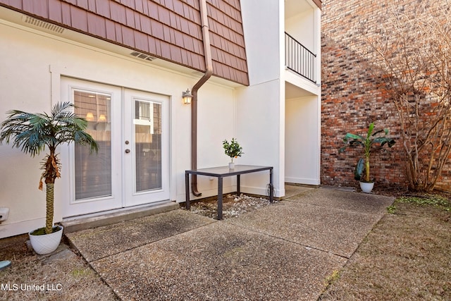 view of exterior entry with french doors and a patio