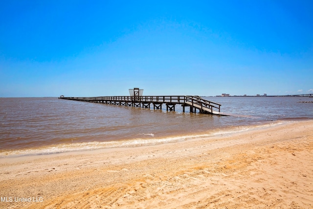 dock area featuring a water view and a beach view