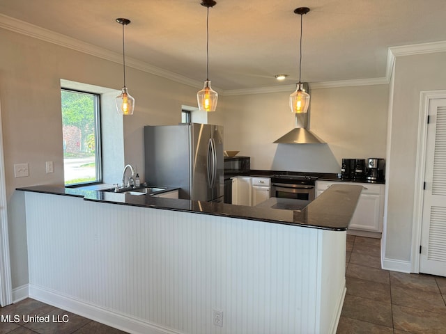 kitchen with kitchen peninsula, appliances with stainless steel finishes, wall chimney exhaust hood, sink, and decorative light fixtures