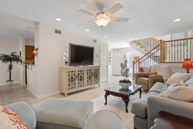 tiled living room with ceiling fan and a textured ceiling