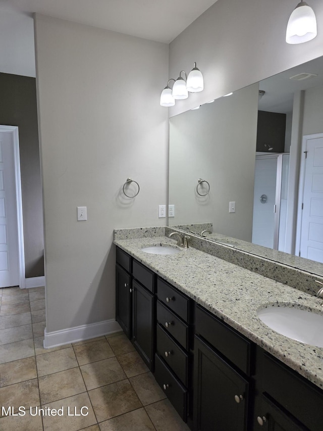 45 Carlsbad, Hattiesburg, MS 39402 - bathroom featuring baseboards, double vanity, tile patterned floors, and a sink