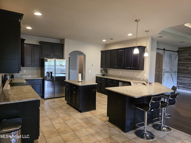 45 Carlsbad, Hattiesburg, MS 39402 - kitchen featuring a barn door, a sink, stainless steel fridge with ice dispenser, arched walkways, and a peninsula