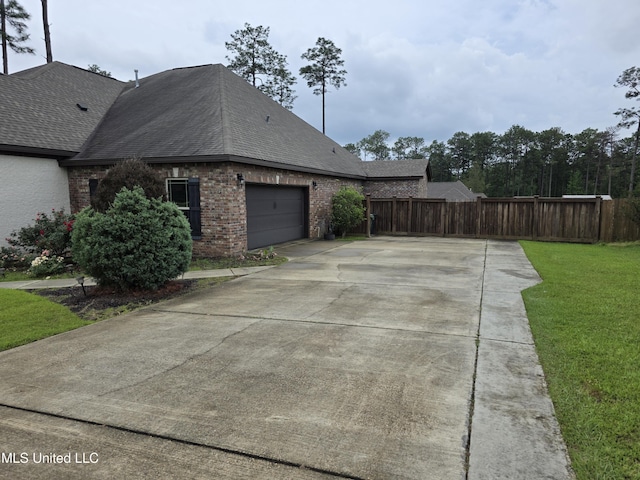 45 Carlsbad, Hattiesburg, MS 39402 - view of property exterior featuring fence, brick siding, a garage, a yard, and driveway
