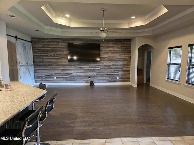45 Carlsbad, Hattiesburg, MS 39402 - unfurnished living room featuring visible vents, tile patterned flooring, a barn door, a raised ceiling, and an accent wall