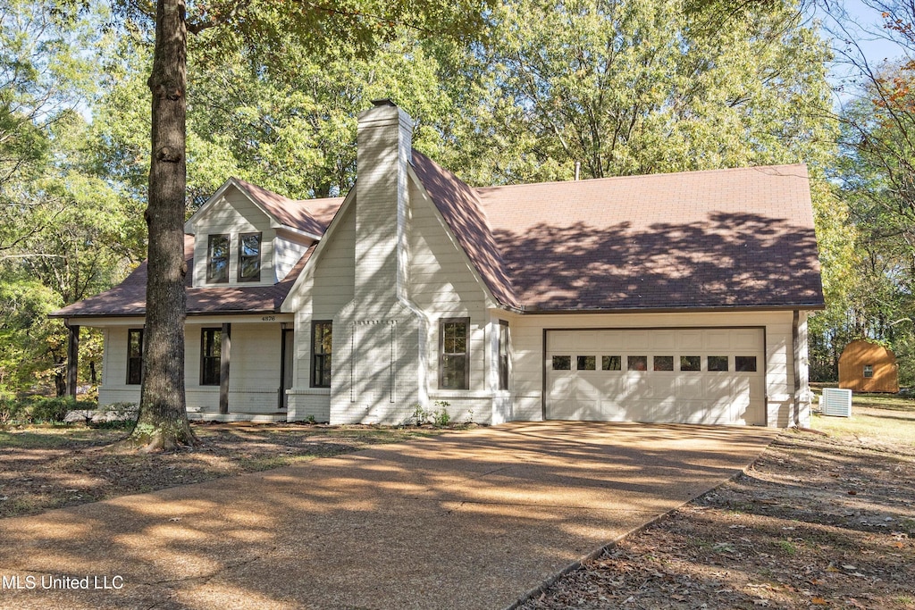 view of front facade with cooling unit and a garage