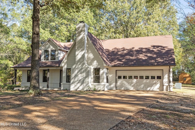 view of front facade with cooling unit and a garage