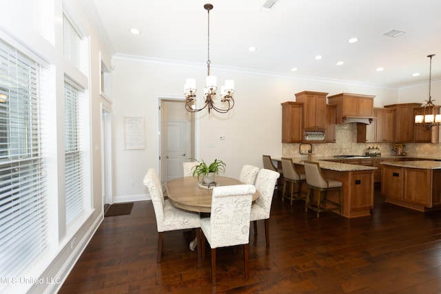 dining space featuring dark wood-type flooring, ornamental molding, and a chandelier