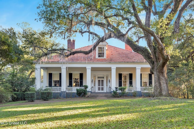 view of front facade with covered porch and a front lawn