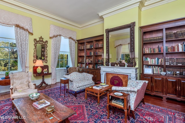 sitting room with ornamental molding and dark wood-type flooring