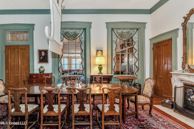 dining area with ornamental molding and a premium fireplace