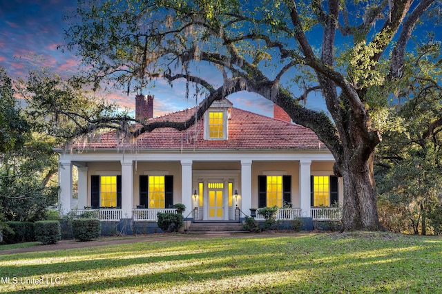 view of front of home featuring covered porch and a lawn