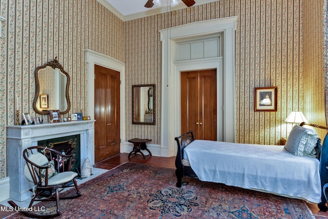 bedroom with hardwood / wood-style floors, ceiling fan, and crown molding