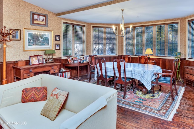 dining room featuring a notable chandelier, dark hardwood / wood-style flooring, and wooden walls