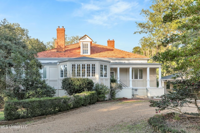 back of property featuring covered porch