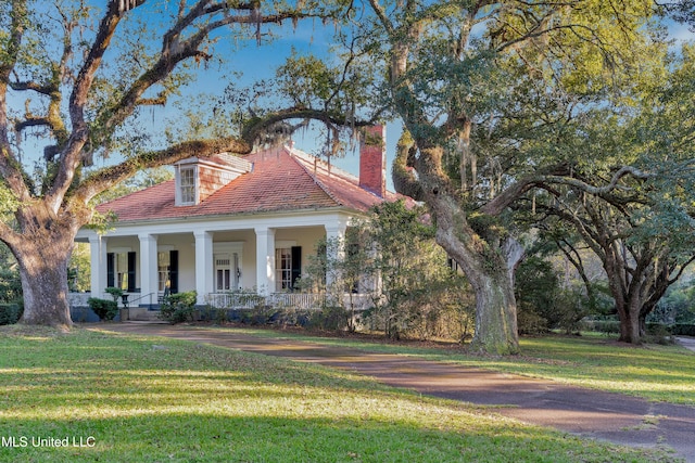 view of front of property with a porch and a front lawn