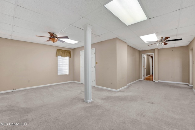 empty room featuring a paneled ceiling, ceiling fan, and baseboards