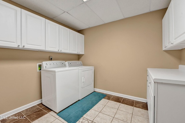 laundry room with light tile patterned flooring, washing machine and dryer, cabinet space, and baseboards