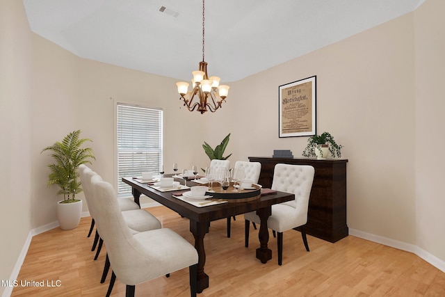 dining area with a chandelier, light wood-type flooring, visible vents, and baseboards