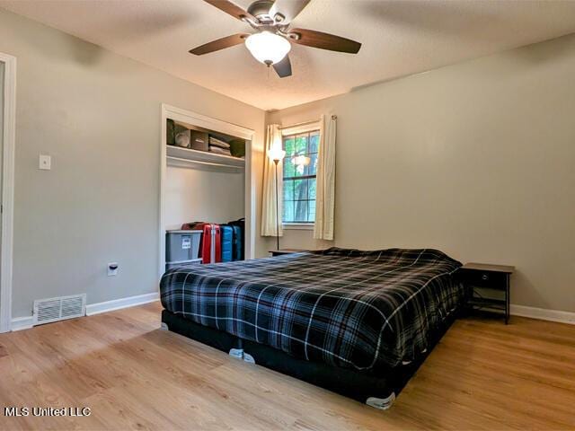 bedroom with ceiling fan, a closet, and wood-type flooring