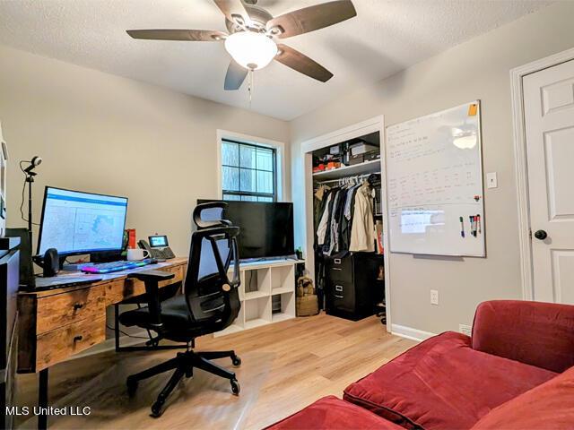 office area with a textured ceiling, hardwood / wood-style flooring, and ceiling fan