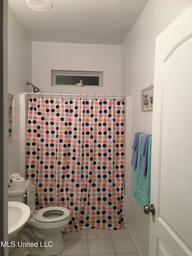 bathroom with tile patterned flooring, curtained shower, and toilet