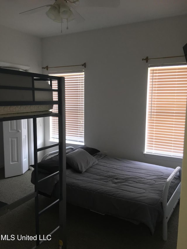 carpeted bedroom featuring ceiling fan and multiple windows