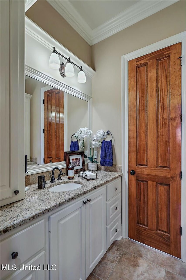 bathroom with ornamental molding and vanity