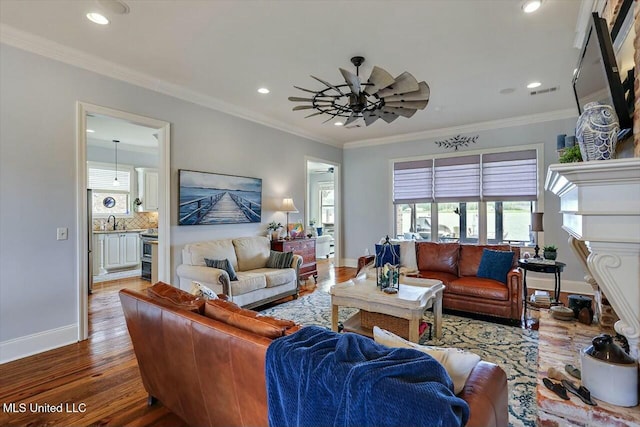 living room with hardwood / wood-style floors, crown molding, sink, and ceiling fan