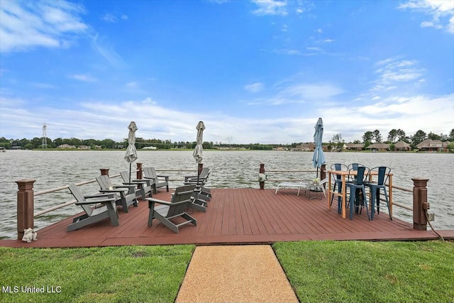 view of dock with a water view and a lawn